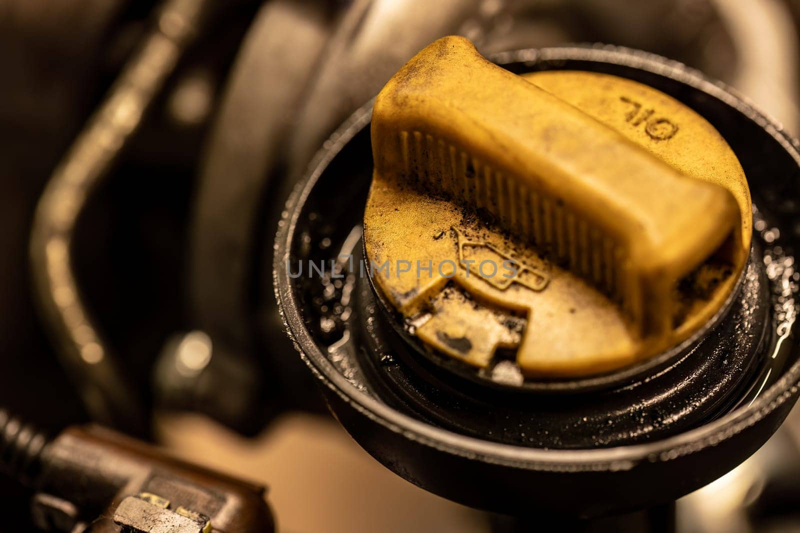 Photo shows a dirty oil cap on a car engine, symbolizing the urgent need for vehicle maintenance.