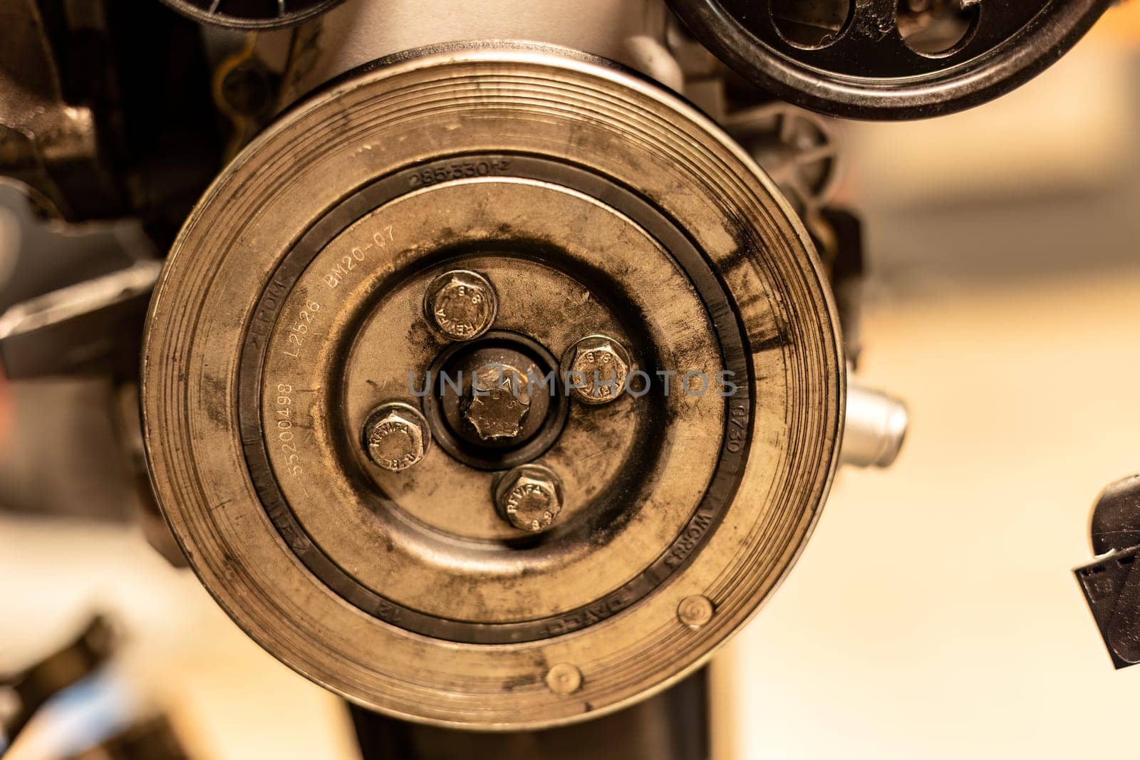 Photo focusing on the intricate pulleys of a car engine by pippocarlot