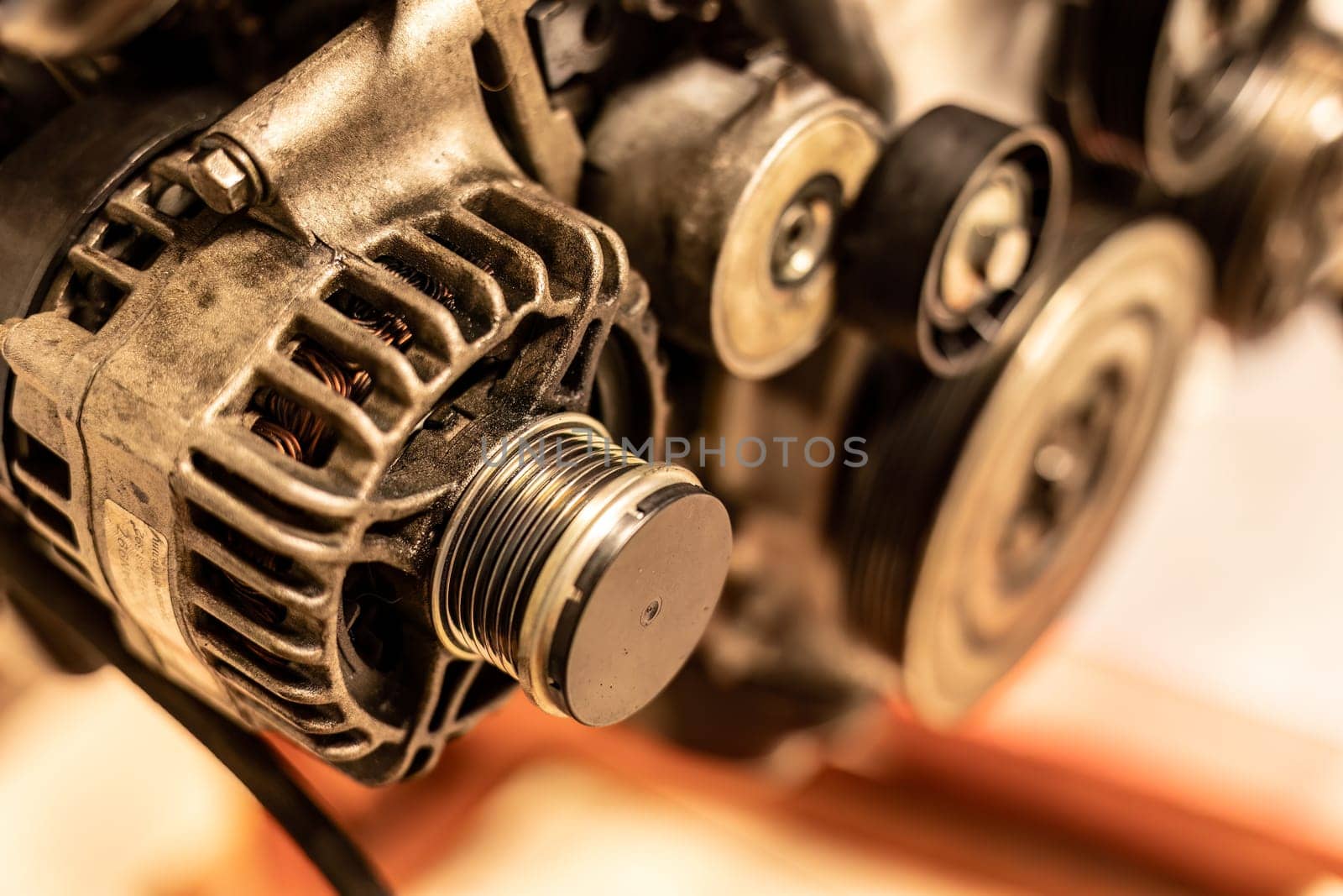 Detailed image of an alternator pulley attached to a car engine, showcasing intricate mechanical parts.
