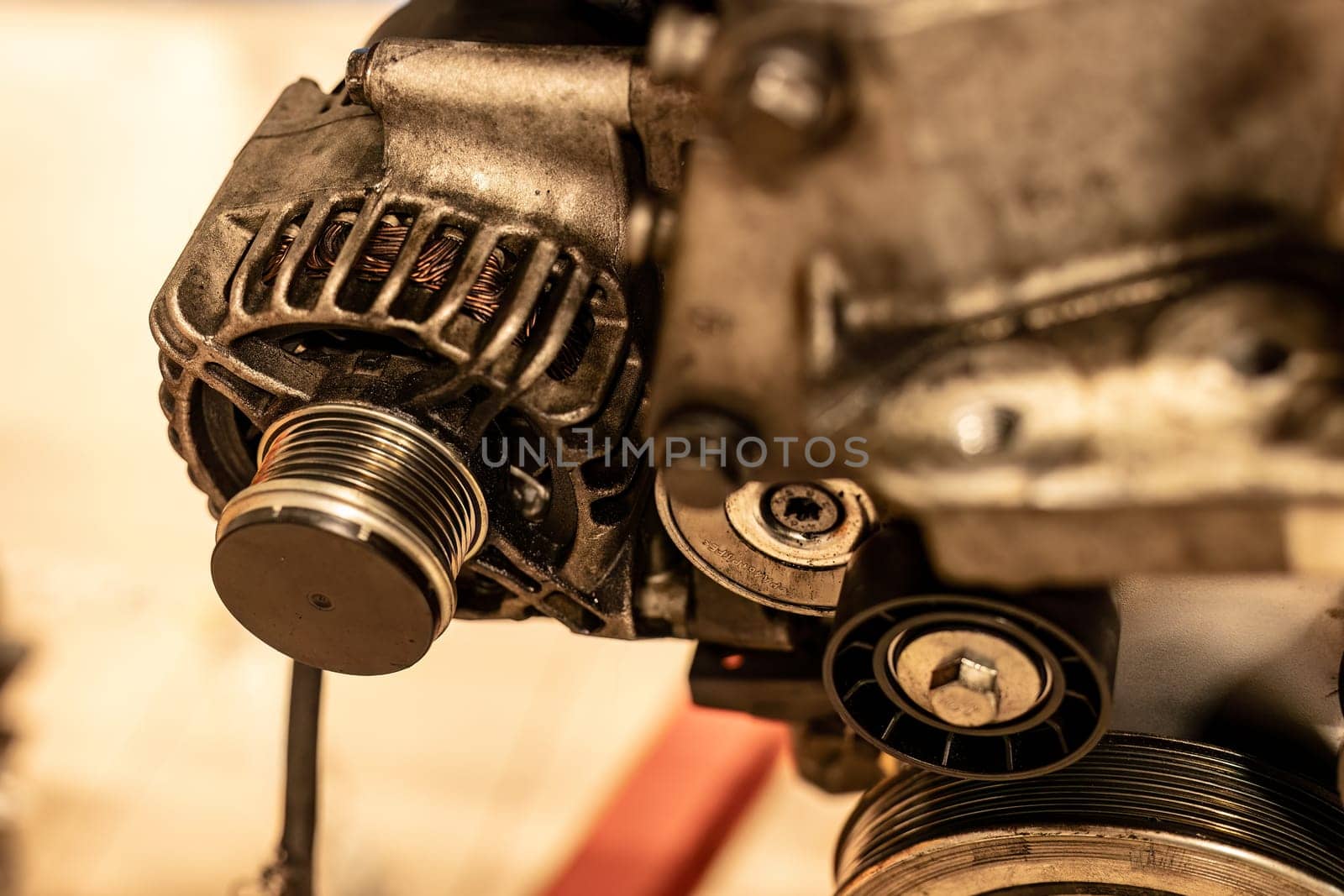 Detailed image of an alternator pulley attached to a car engine, showcasing intricate mechanical parts.