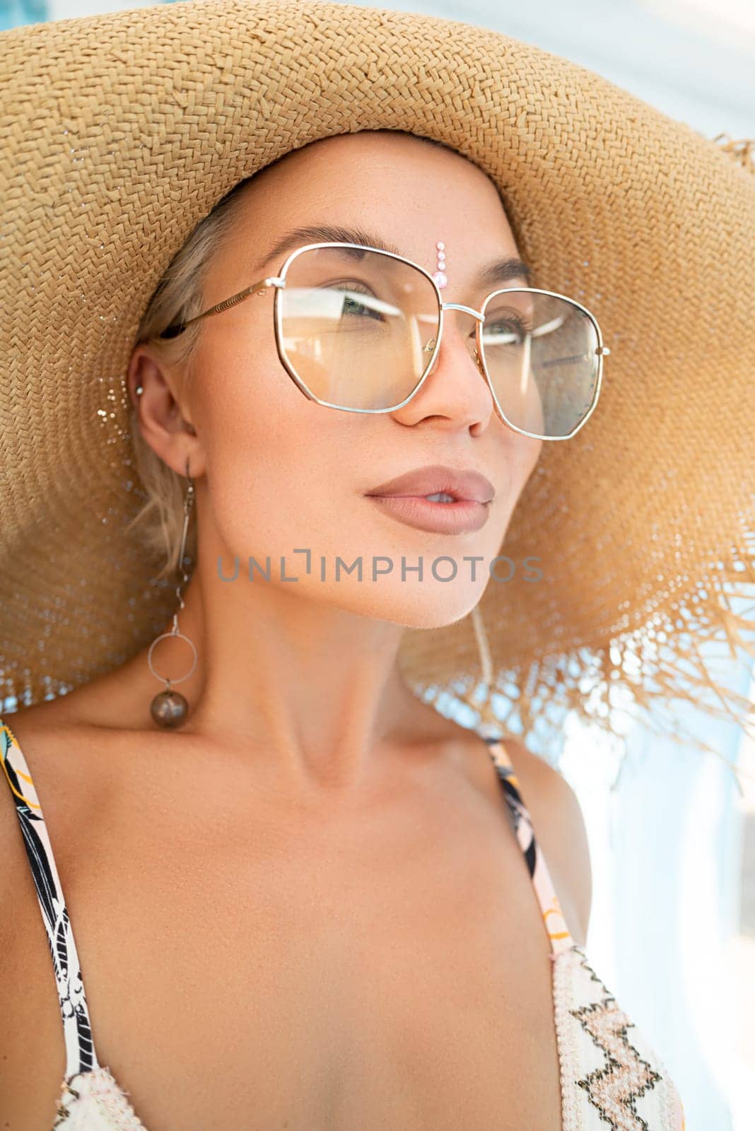 sexy young girl in a straw hat on vacation smiles, gets high and enjoys life in the summer