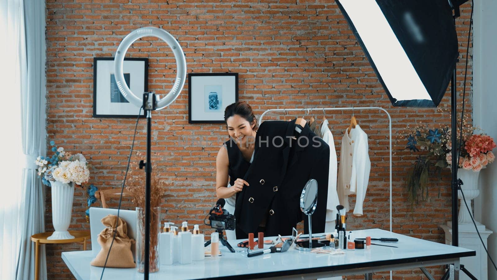 Woman influencer shoot live streaming vlog video review clothes social media or blog. Happy young girl with apparel vivancy studio lighting for marketing recording session broadcasting online.