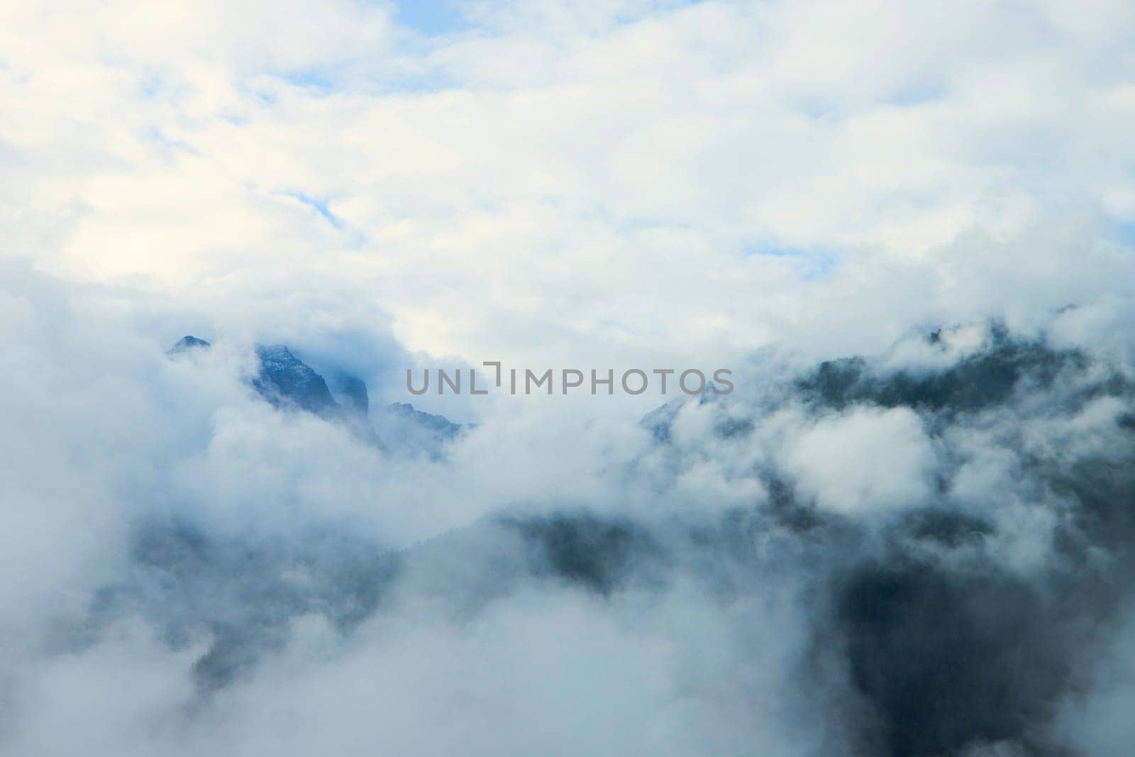 Amidst the Clouds: Alpine Peaks Dancing with the Sky. High quality photo