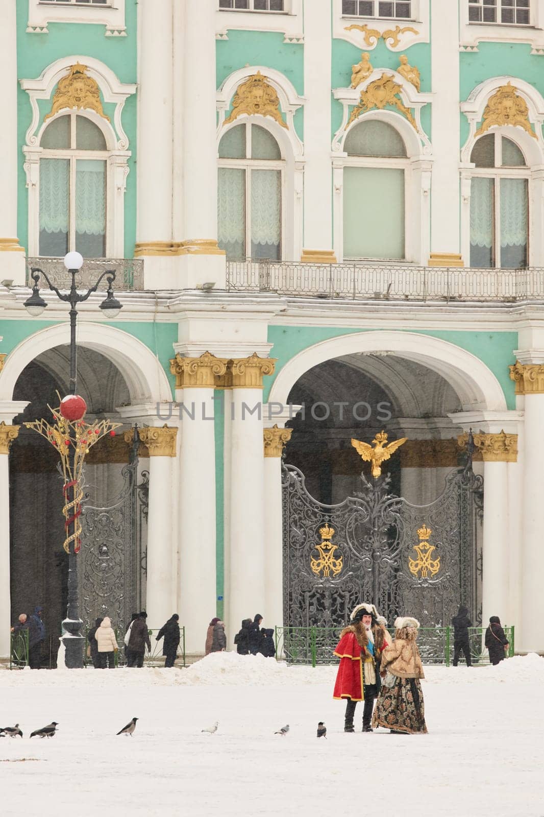 Russia, Saint Petersburg, 30 December 2023 - Actors in the role of Peter the Great and Catherine the Great walk across the square Palace at snowfall, The Hermitage building on background by vladimirdrozdin
