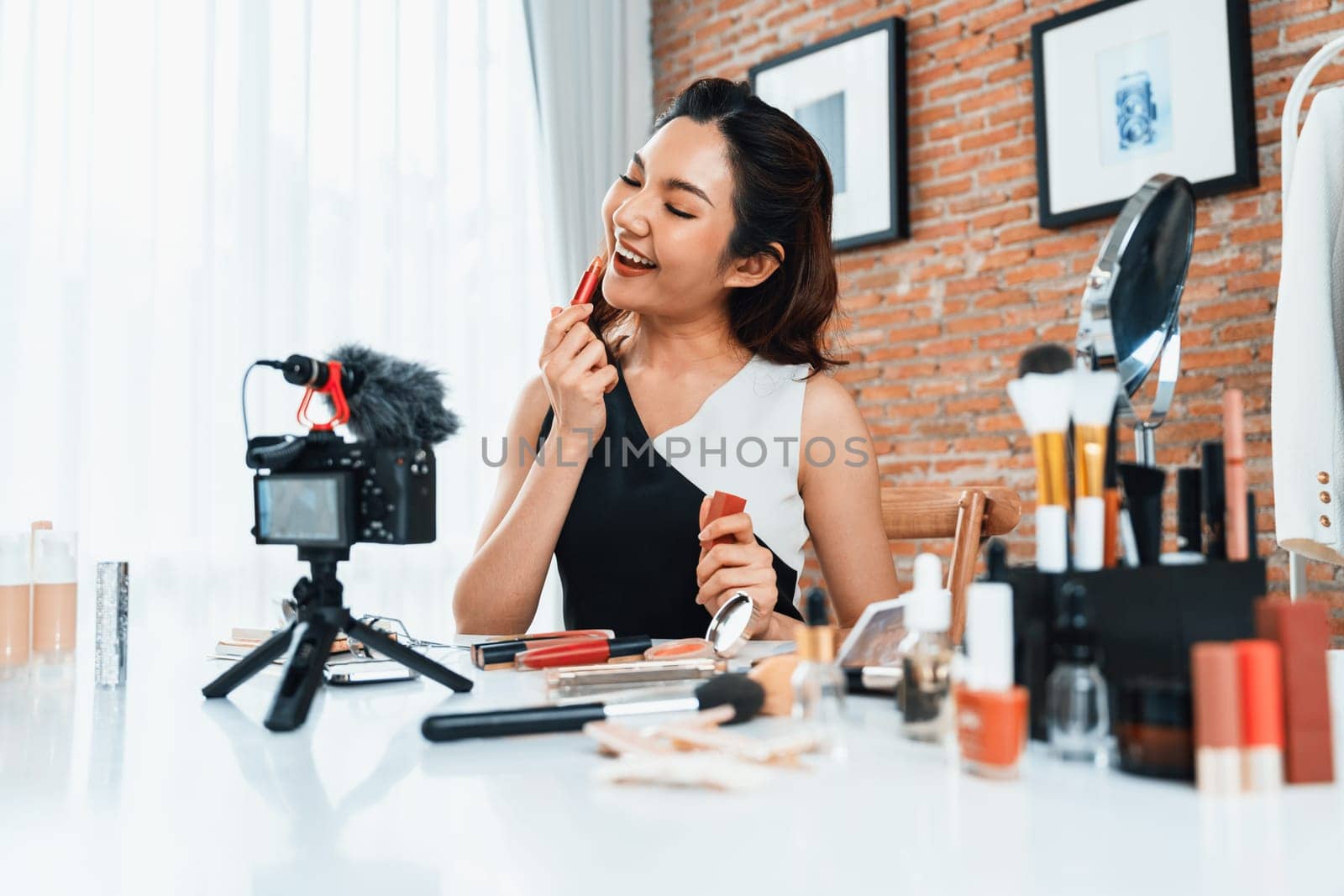 Woman influencer shoot live streaming vlog video review makeup uttermost social media or blog. Happy young girl with cosmetics studio lighting for marketing recording session broadcasting online.