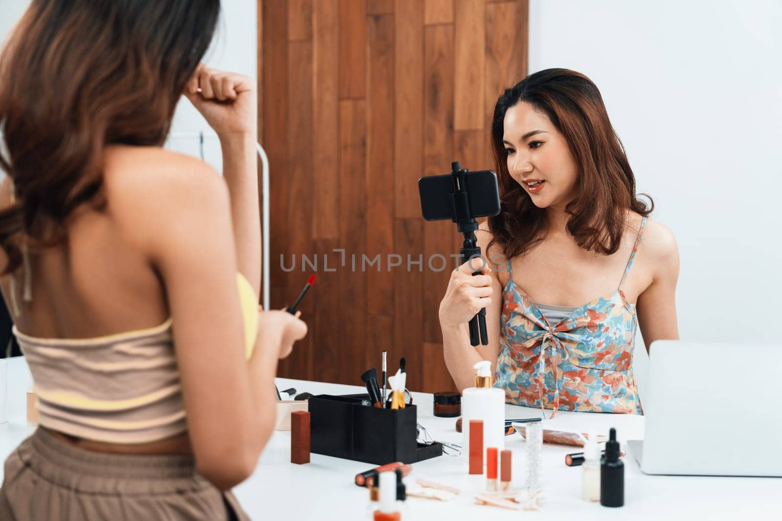 Woman influencer shoot live streaming vlog video review makeup uttermost social media or blog. Happy young girl with cosmetics studio lighting for marketing recording session broadcasting online.