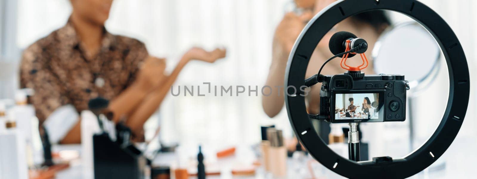 Woman influencer shoot live streaming vlog video review makeup crucial social media or blog. Happy young girl with cosmetics studio lighting for marketing recording session broadcasting online.