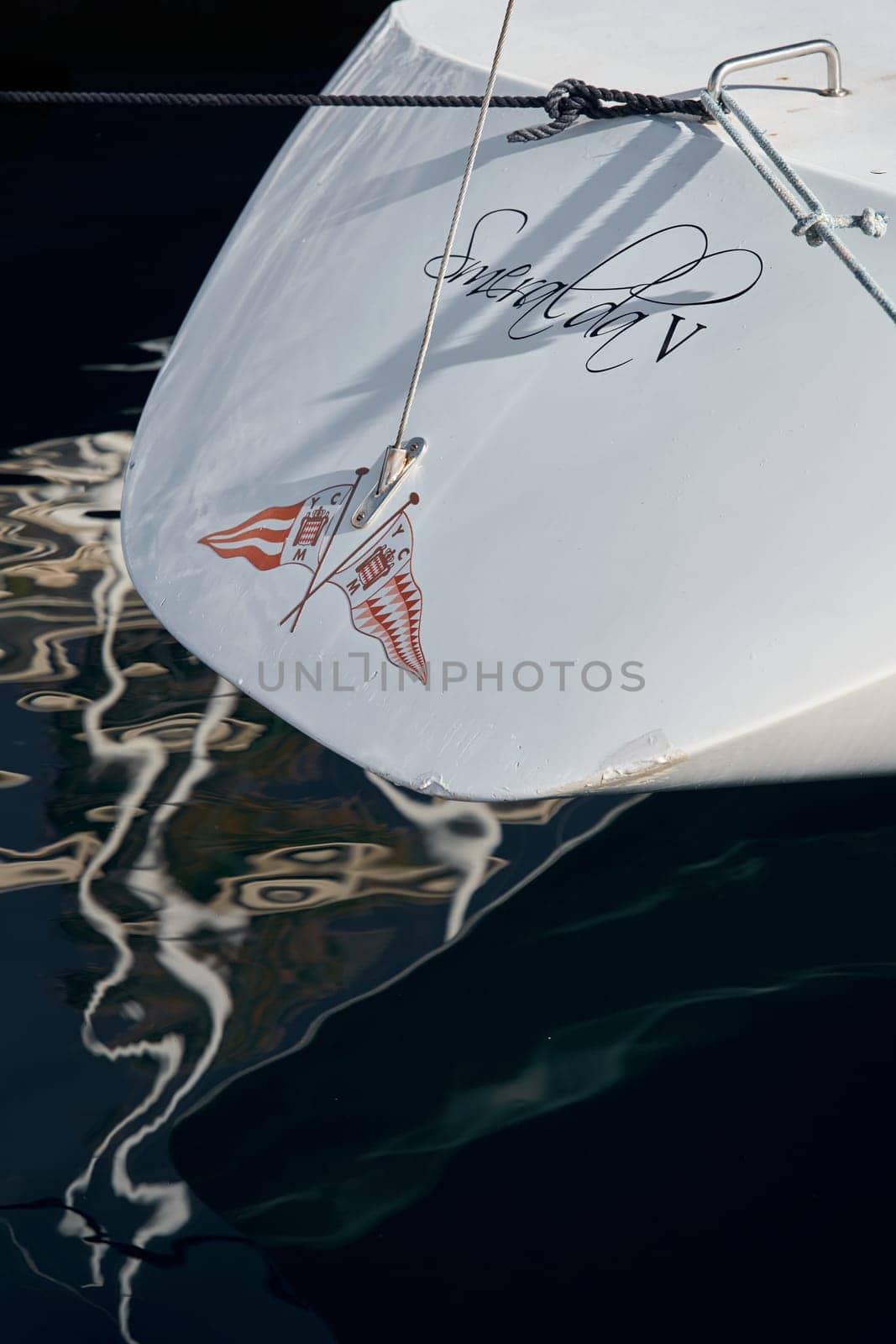 Monaco, Monte-Carlo, 26 October 2022: Logo of new Yacht Club on glossy board of moored sail boat, azure water, tranquillity in port Hercules at sunny day by vladimirdrozdin