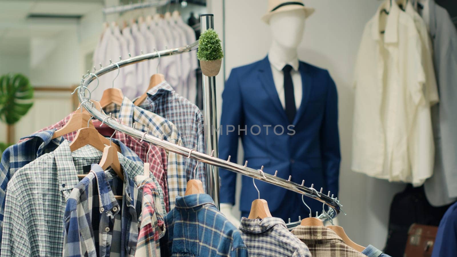 Panning shot of elegant selection of shirts on hangers in high end fashion boutique showcasing trendy, stylish garments from their new collection. Close up on men shirts in mall clothing store