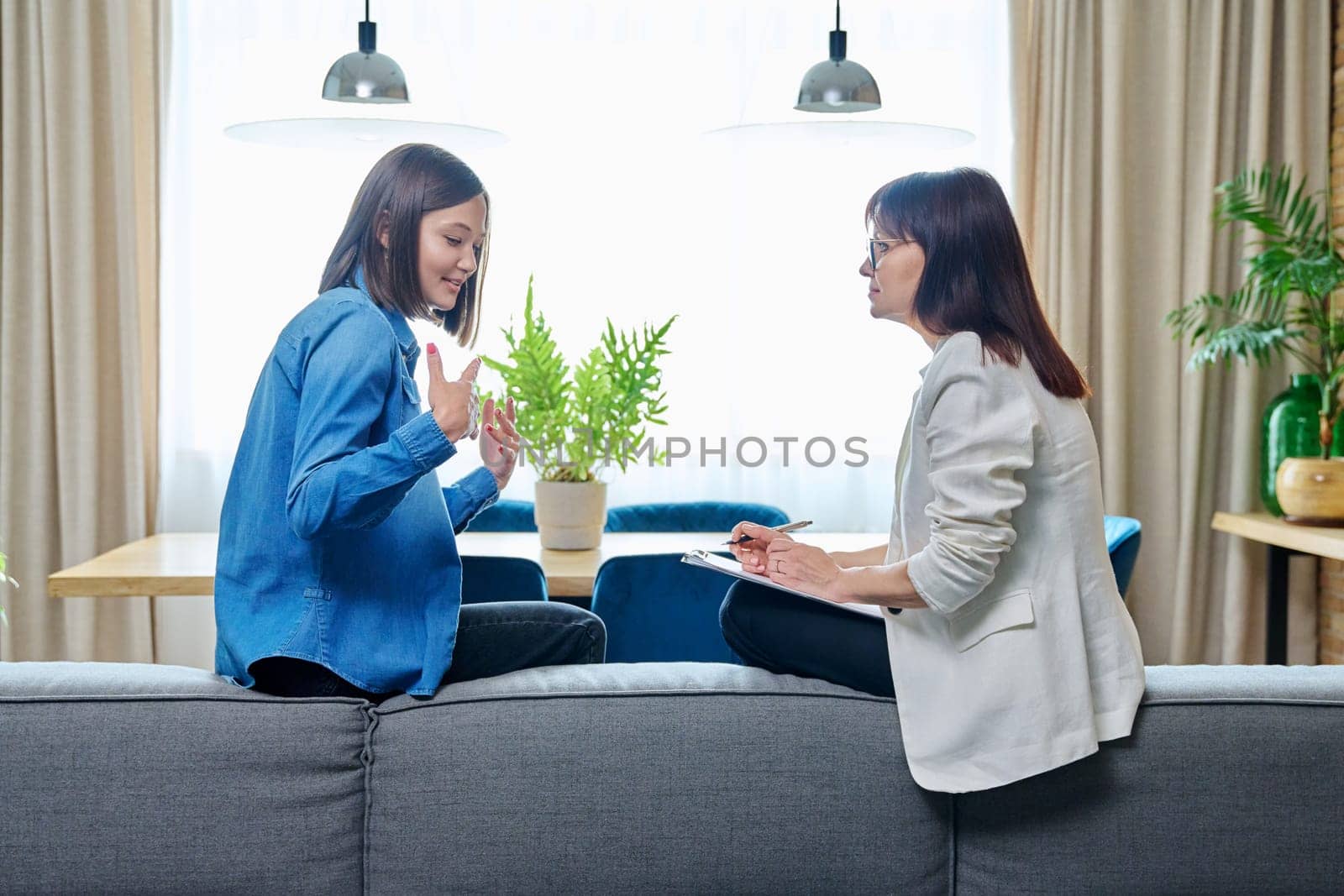 Happy young woman patient talking to female psychologist at therapy by VH-studio