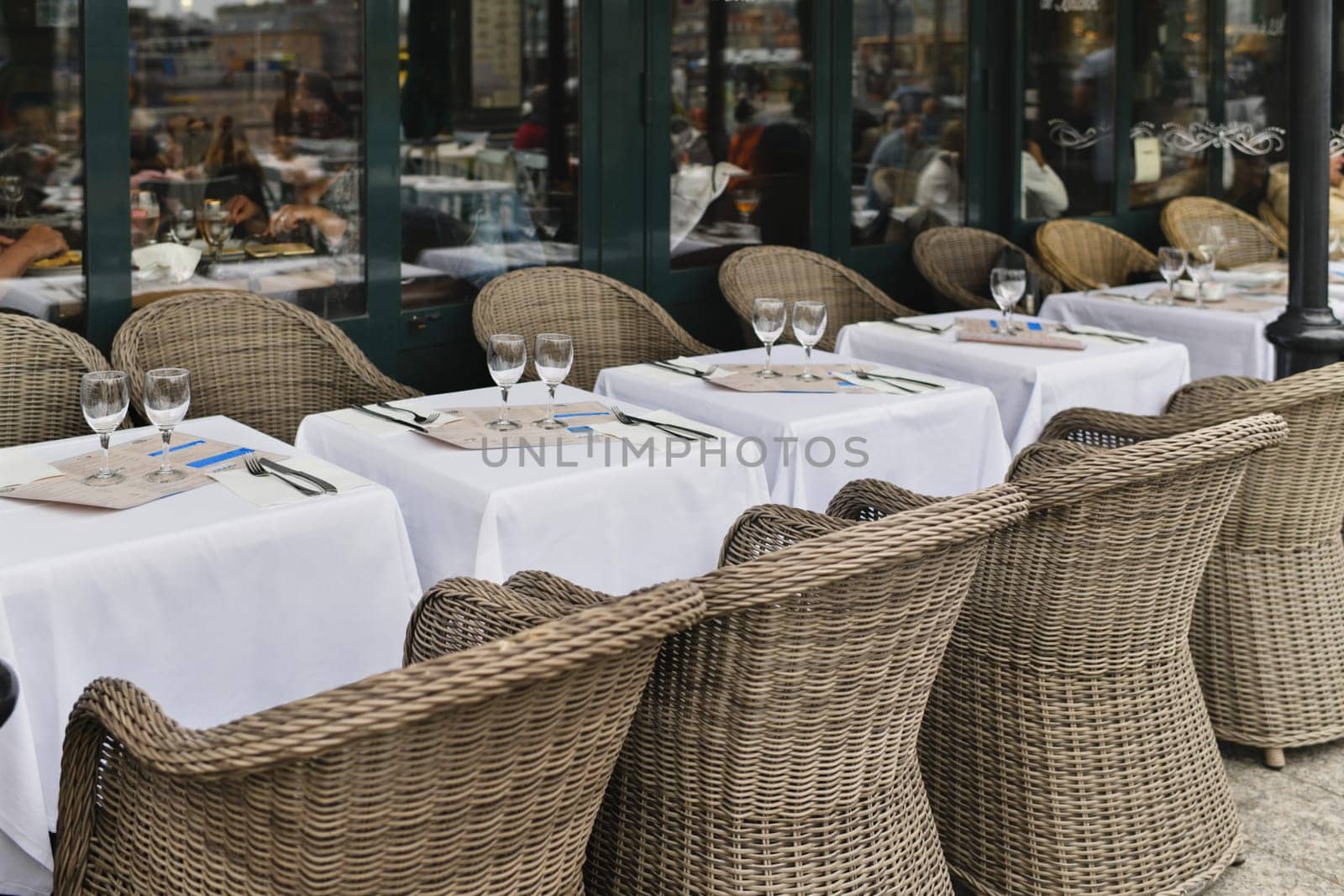 Traditional Parisian cafe with wicker chairs by Godi