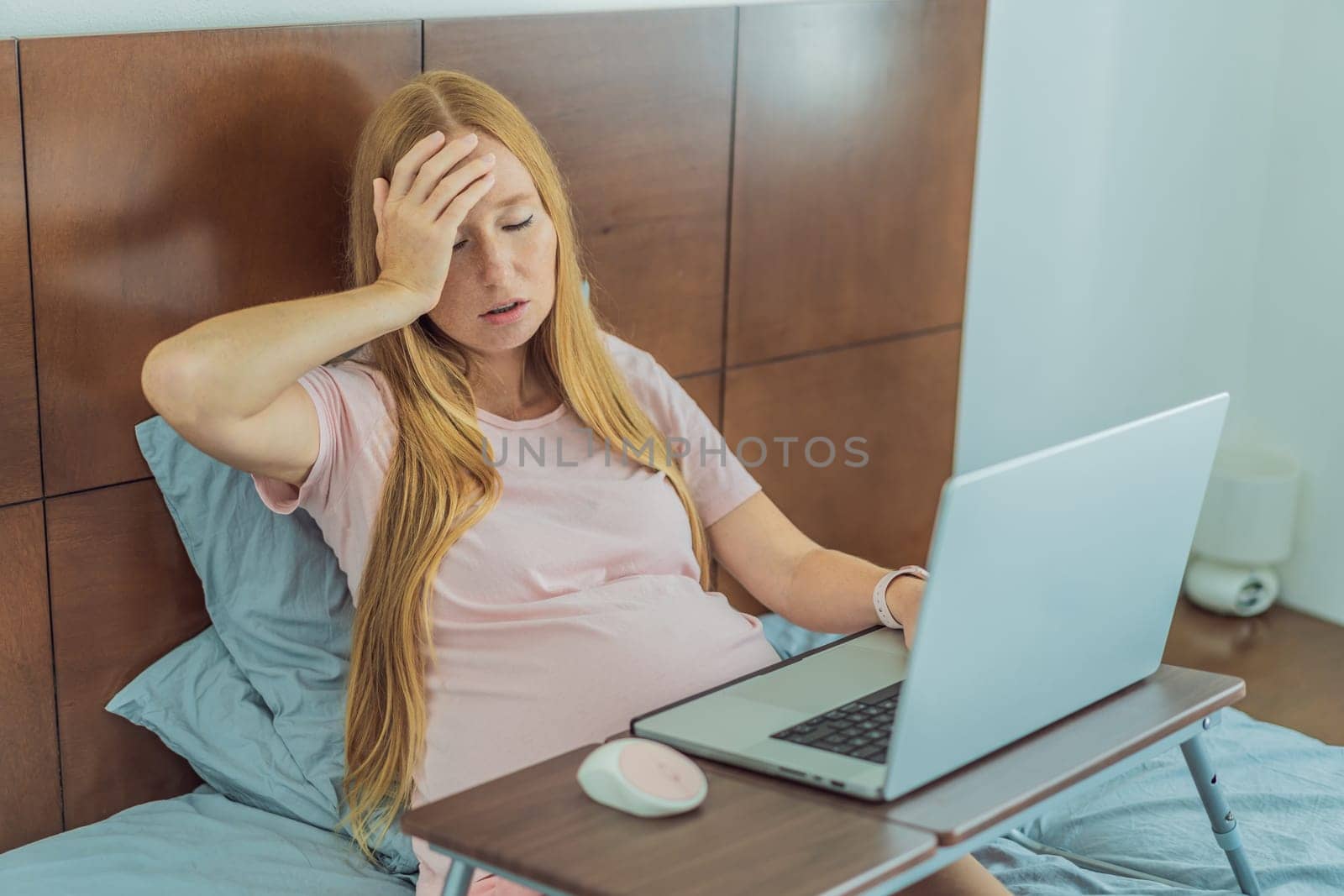 Weary pregnant woman, tired of working from home, navigates the challenges of balancing professional tasks with pregnancy demands.