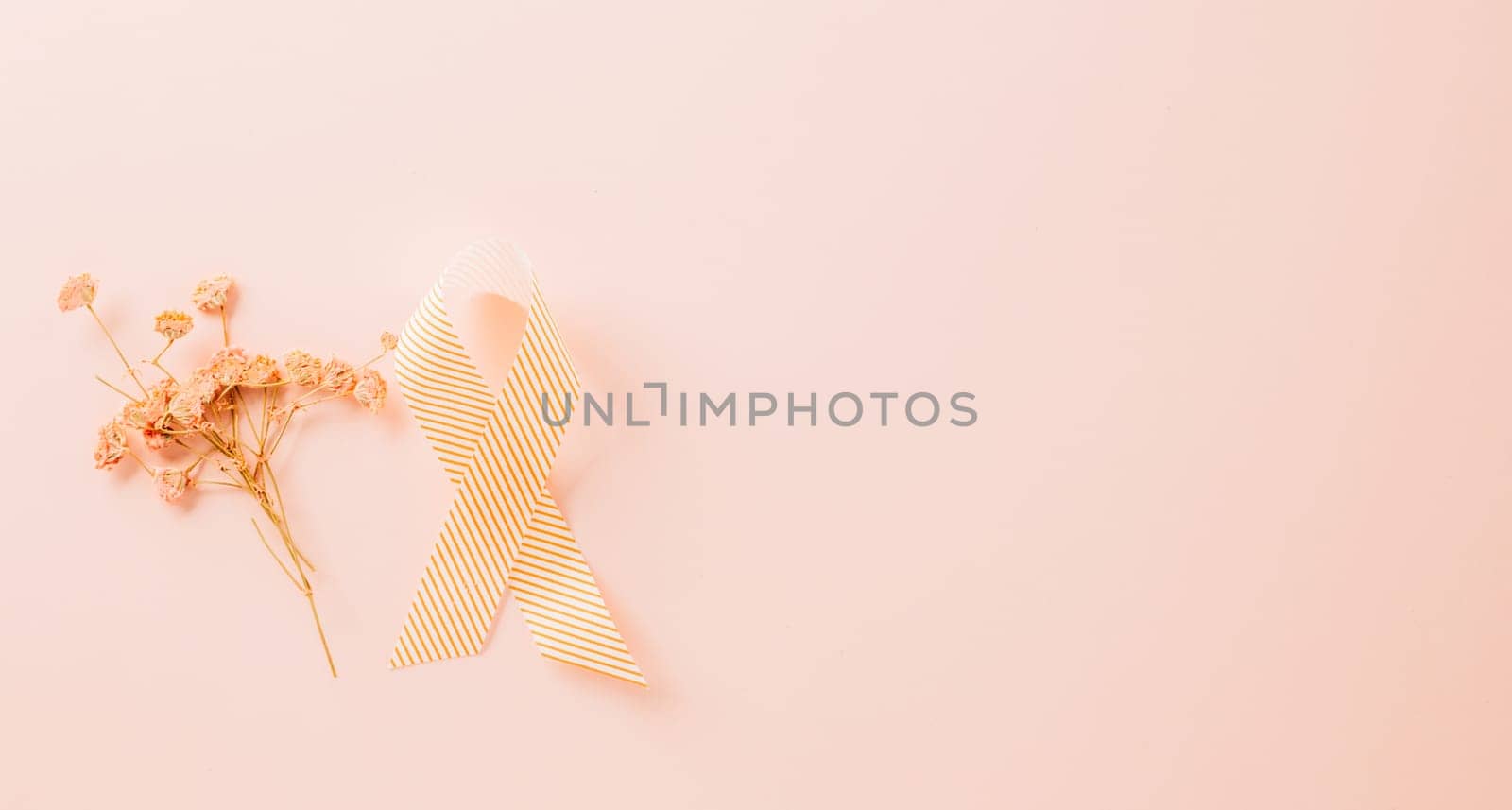 Pink awareness ribbon sign and paper card flower of World Cancer Day by Sorapop