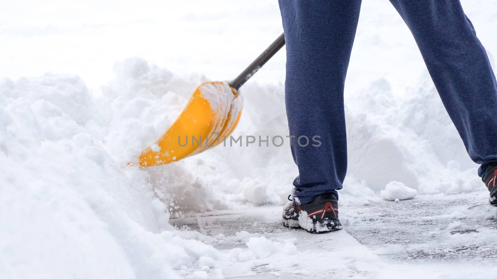 Man shoveling snow off of his driveway after a winter storm in Canada. Man with snow shovel cleans sidewalks in winter. Winter time