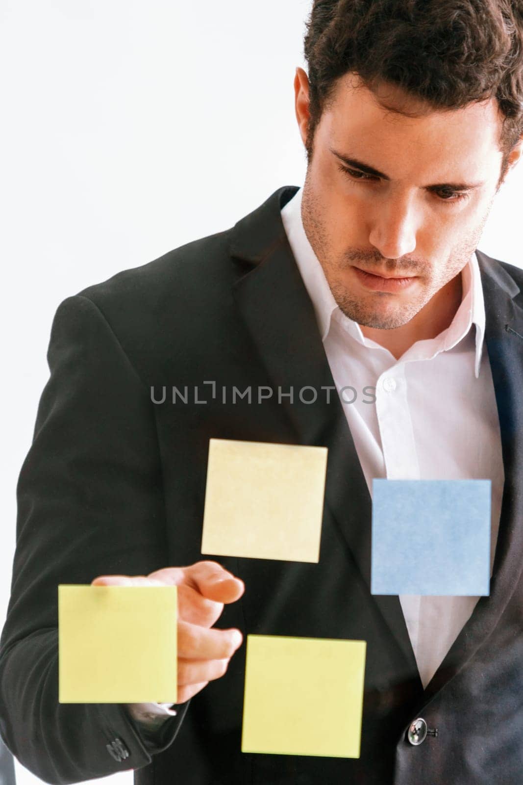 Serious businessman feels disappointed while looking at sticky note on the windows in the office. Bankruptcy and failure concept. uds