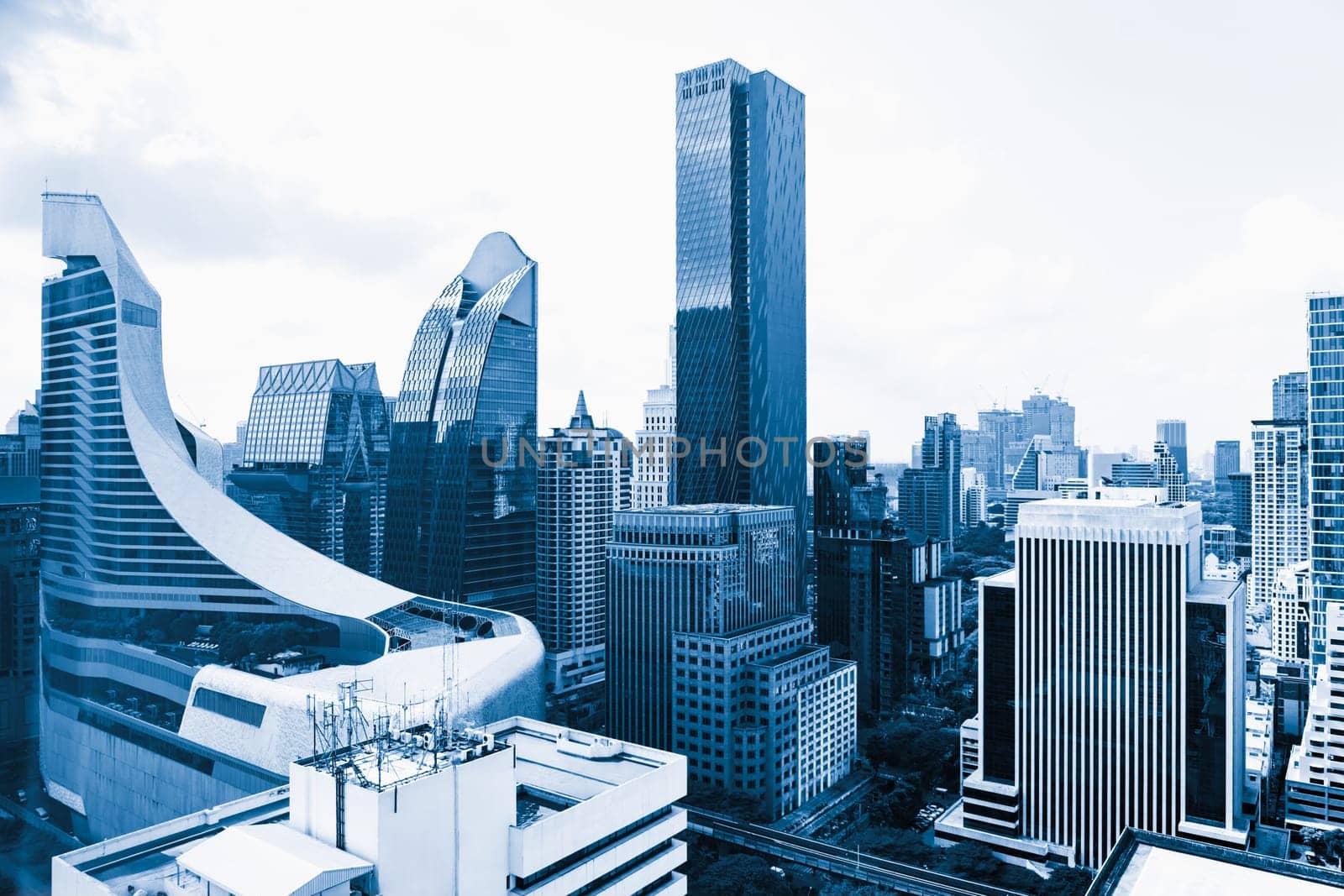 Closeup image of Bangkok cityscape. Modern skyscrapers with monochrome blue filter. Modern architectural building skyline with blue sky. Side view. Business background. Day light. Ornamented.