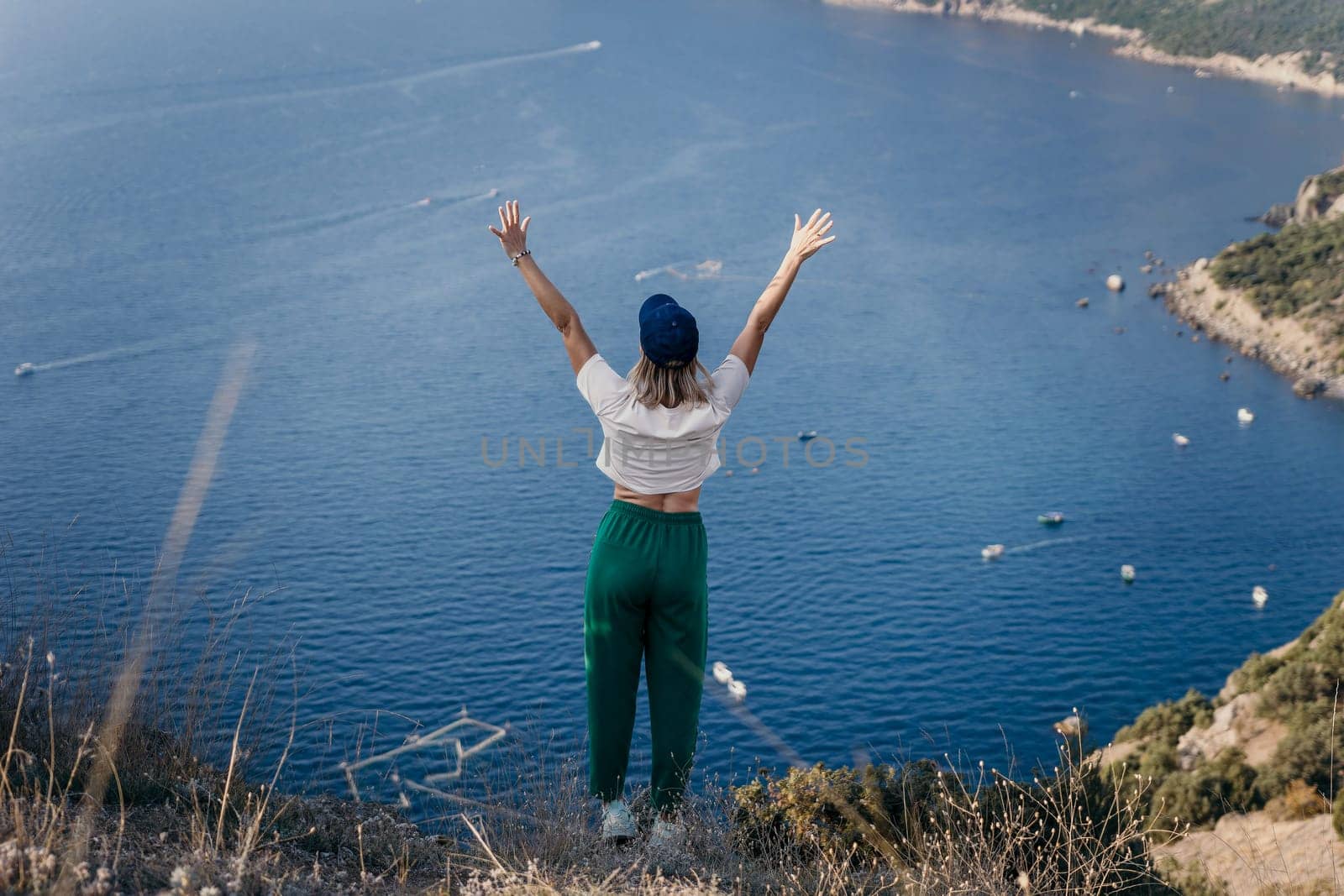 Happy woman standing with her back in nature in summer with open hands posing with mountains. Woman in the mountains, eco friendly, summer landscape active rest.