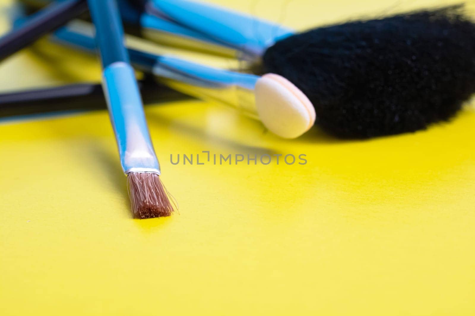 Makeup brushes on a yellow background closeup by Vera1703