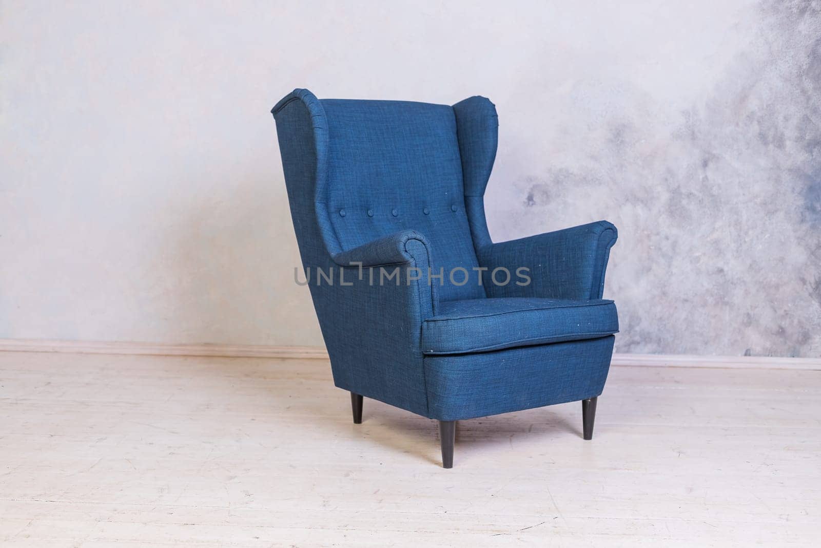 Classic blue chair. loft interior.Comfortable armchair against concrete wall background.Scandinavian style.Minimal Modern Furniture Recliner Object in Elegance Interior. Living Room Fashion Design with Copy Space by YuliaYaspe1979