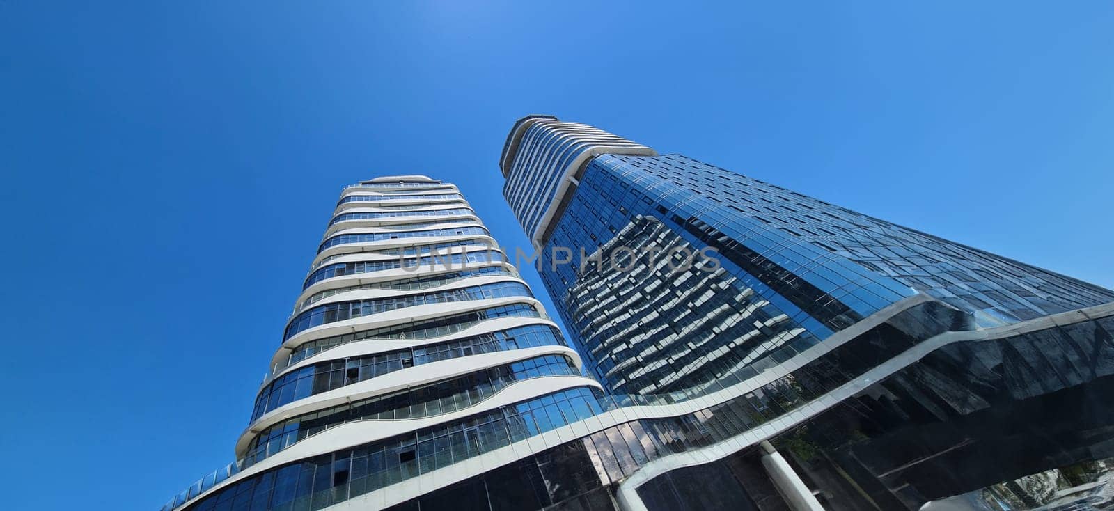 Office building with glass facades in business center. Modern hotel high-rise complex concept