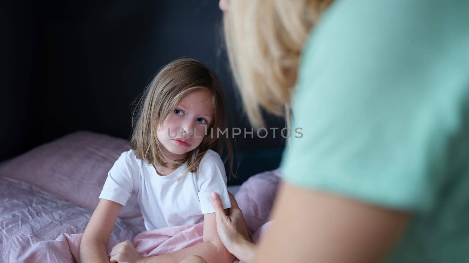 Upset sad little girl communicates with mom at home. Tactile contact of children and parents concept