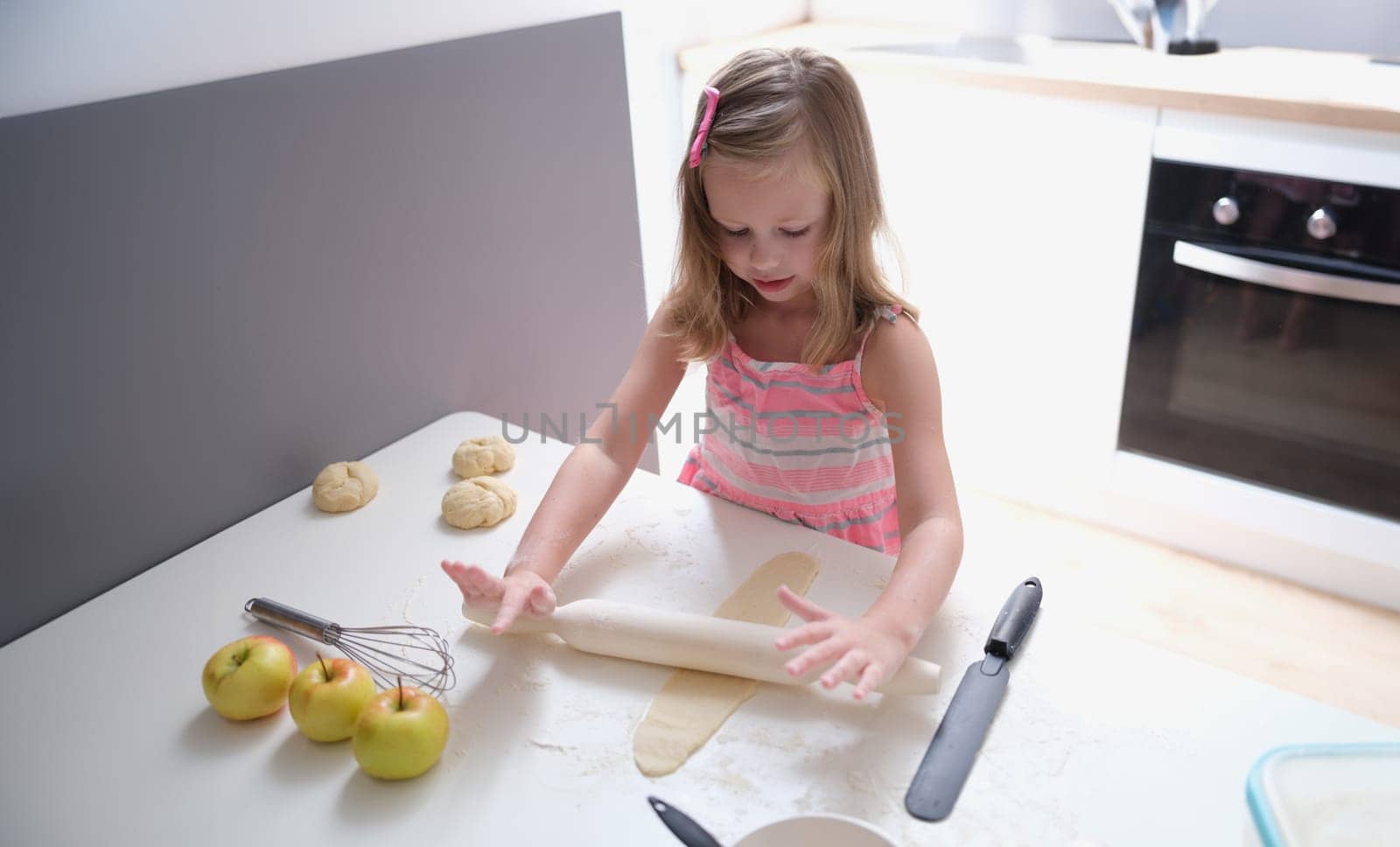 Child girl with rolling pin for baking cookies for dough by kuprevich