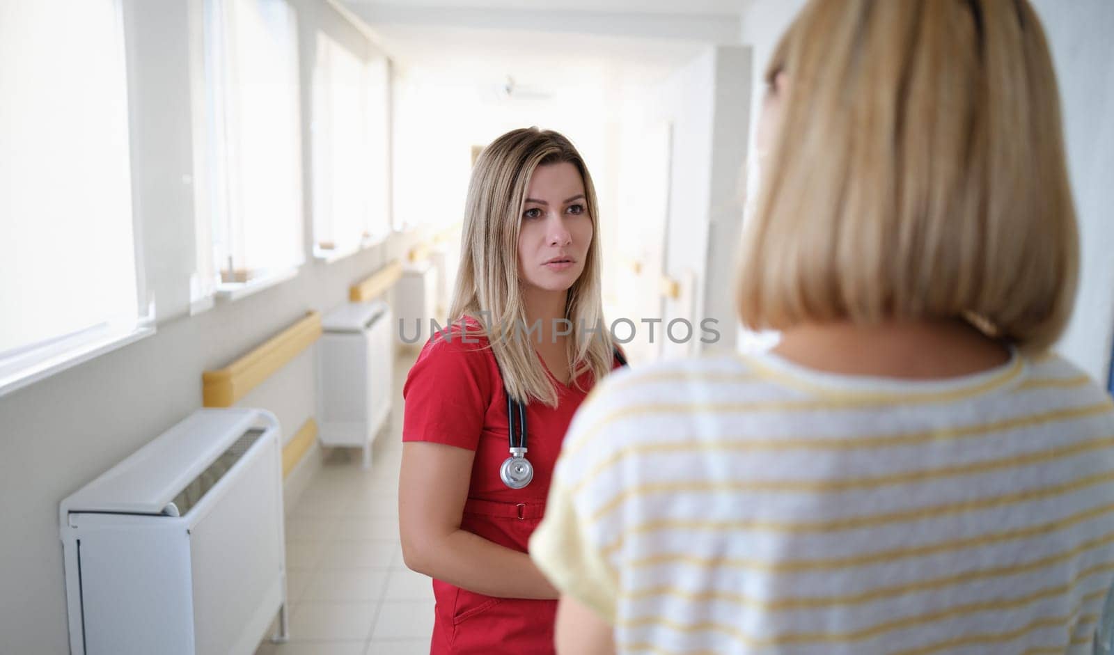 Woman doctor communicates with patient in corridor of hospital. Medicine healthcare and insurance assistance concept