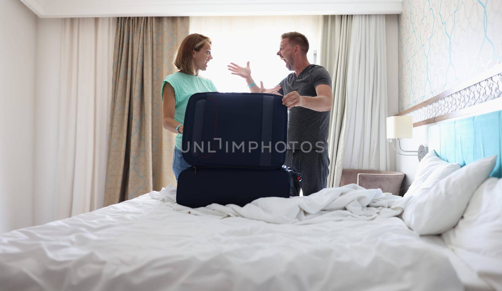 Wife and husband screaming on each other and argue, pack stuff in suitcase, couple fight by kuprevich