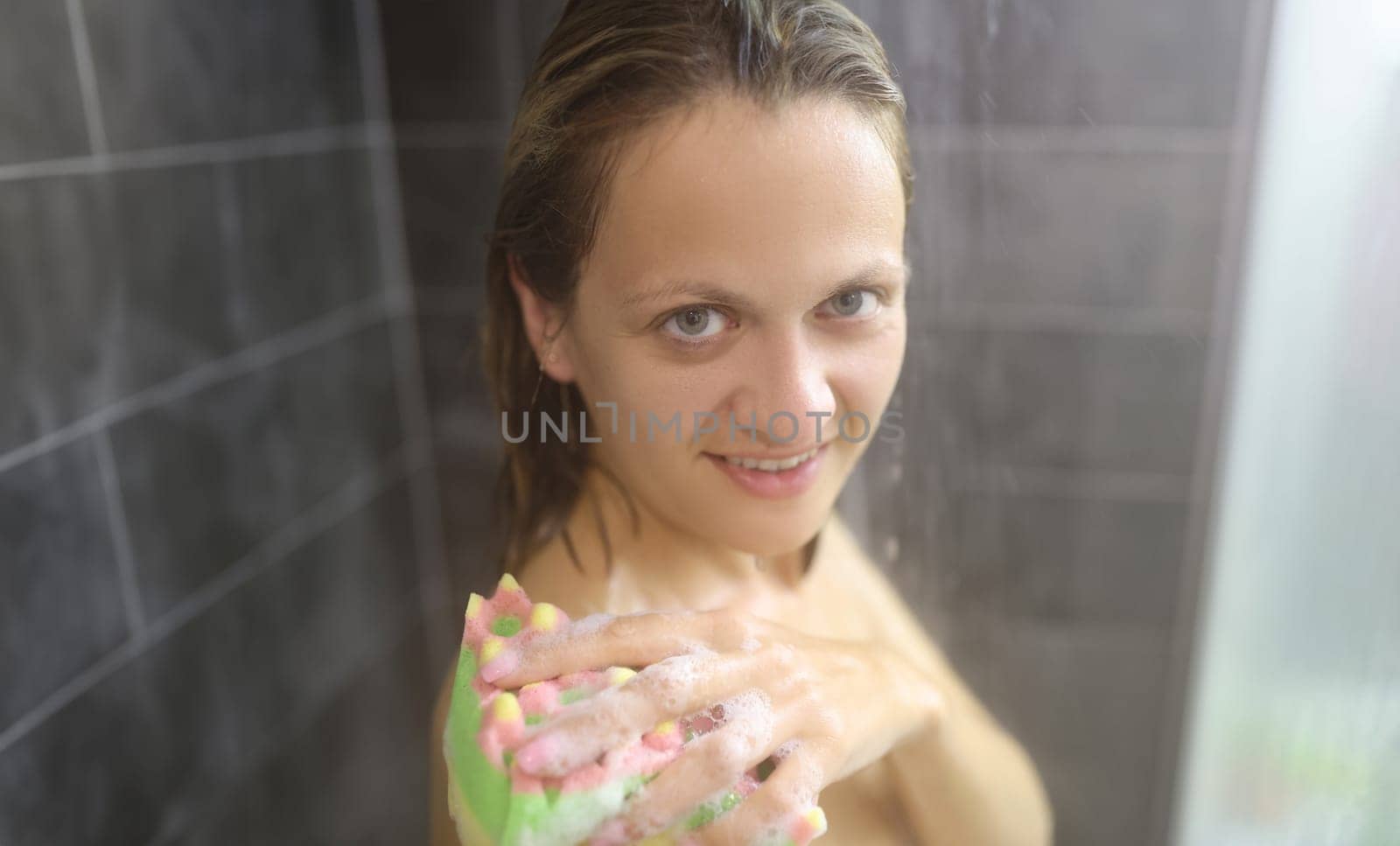Portrait of young woman take hot shower after hard day, cleansing with washcloth. Female topless enjoying running water, release tension. Hygiene concept