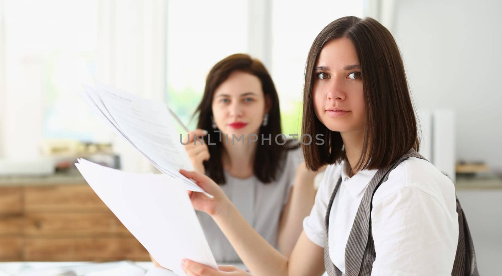 Businesswomen in office with bunch of financial papers, loaded with work by kuprevich