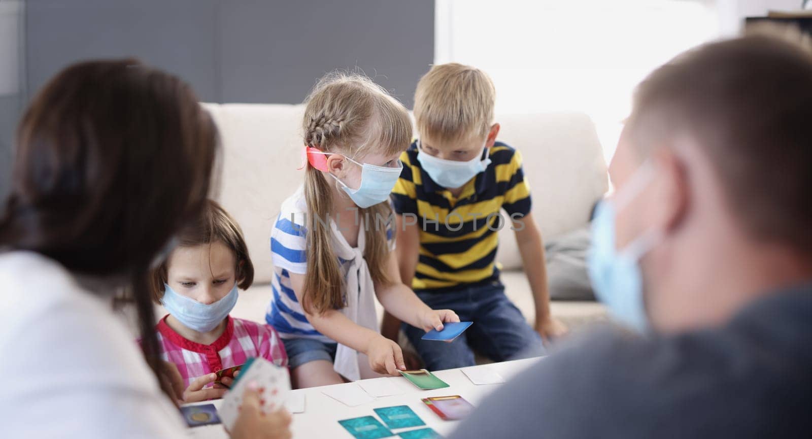 Portrait of kids in face masks, prevent virus spread in kindergarten, developing card game. Task for young generation, learn new things. Quarantine concept