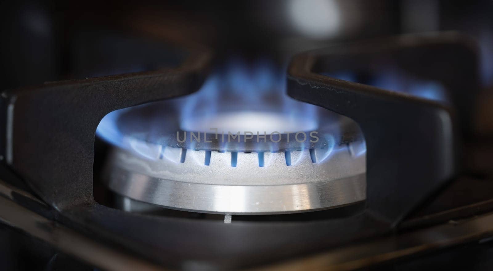 Gas burner on stove with blue fire at home closeup by kuprevich