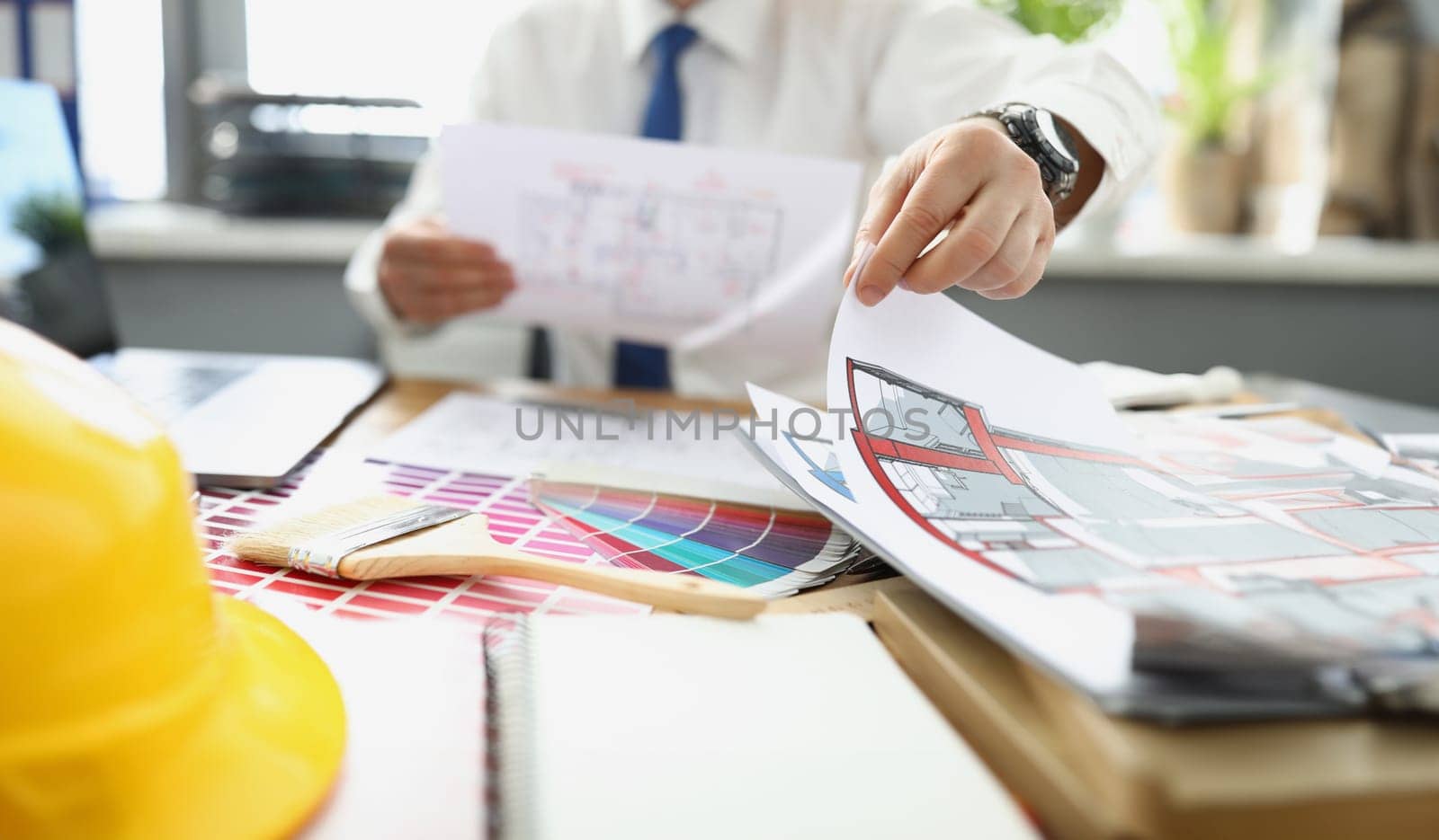 Close-up of successful designer work on new project, palette on desk, house plan. Selection material colour from samples. Architect, creativity concept