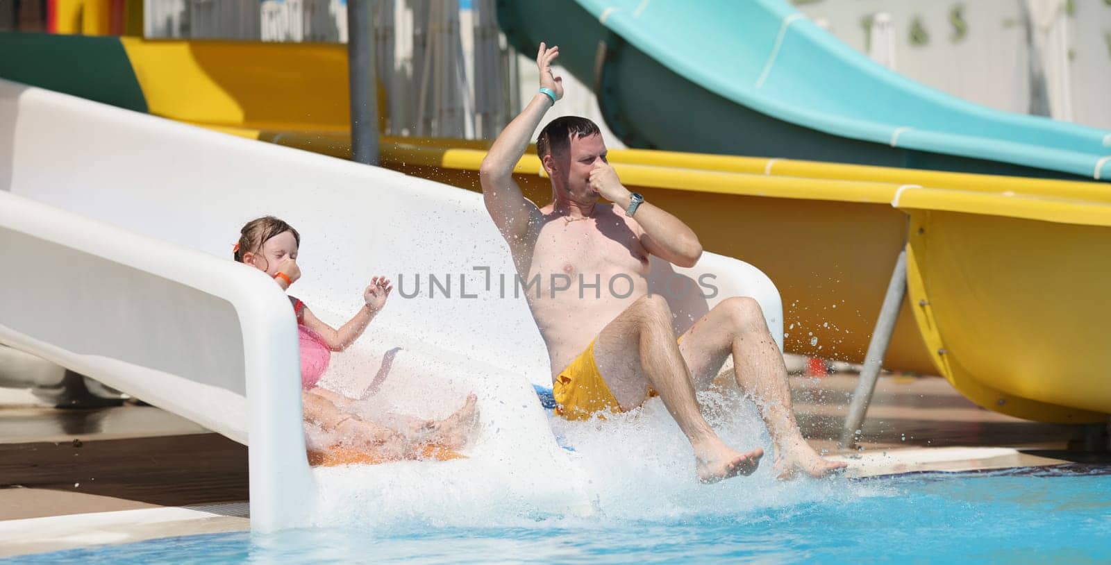 Man father enjoy sliding at water park, summer vacation, go nuts on travel trip by kuprevich