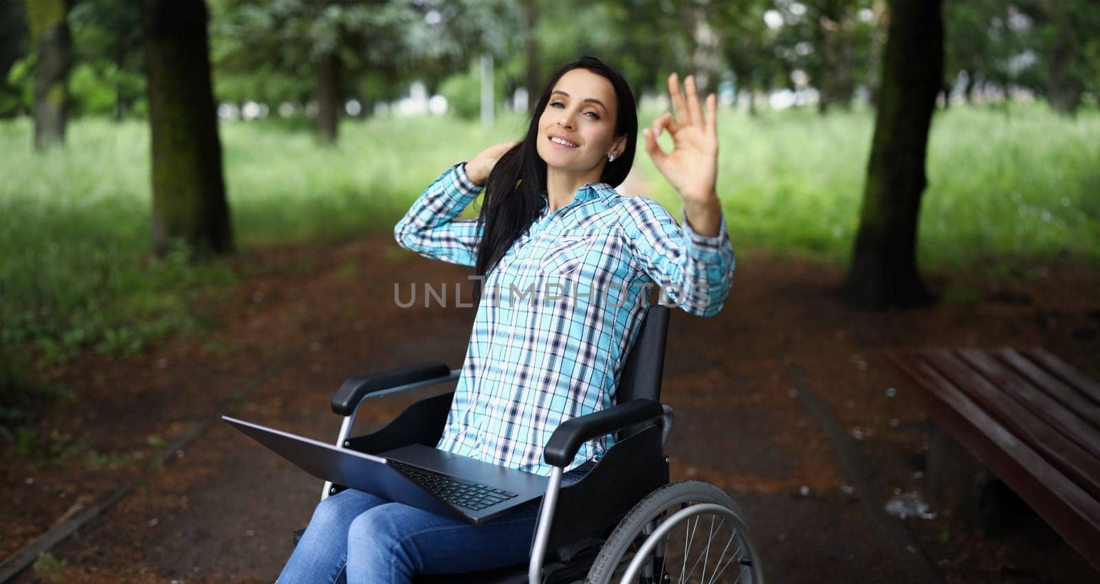 Portrait of woman in wheelchair show ok gesture with hand, work during rehabilitation. Disabled people, recovery, remote job, freelancer, positive concept