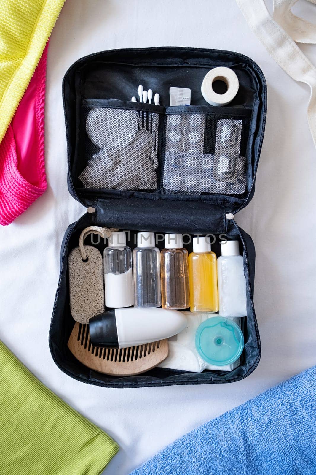 Travel cosmetics kit on bed , top view by Desperada