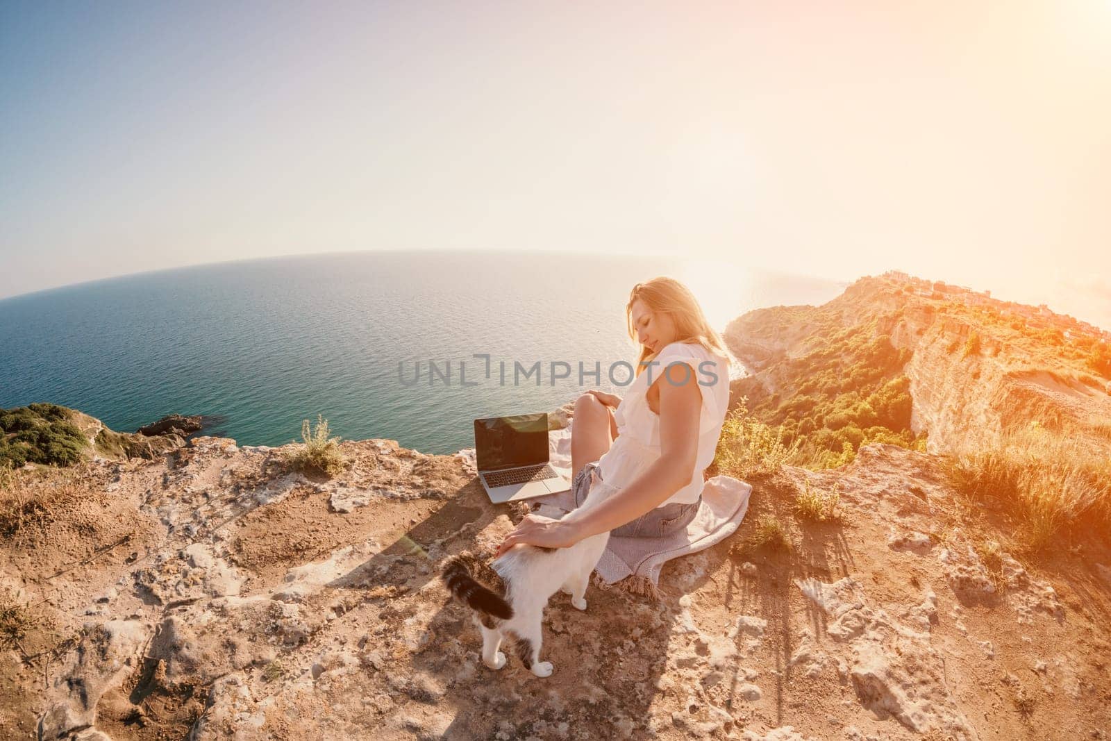 Woman sea laptop. Business woman in yellow hat working on laptop by sea. Close up on hands of pretty lady typing on computer outdoors summer day. Freelance, digital nomad, travel and holidays concept.