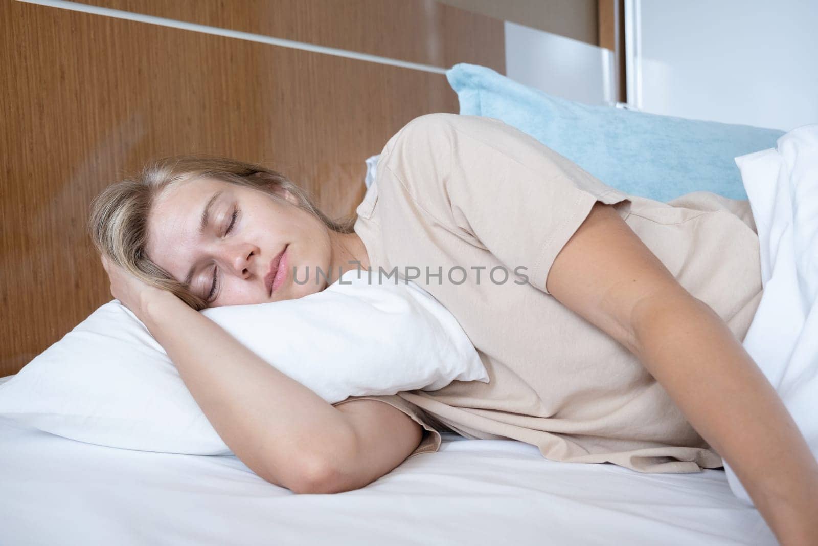 Feeling calmness. Sleepy female keeping eyes closed sleeping at hotel room.