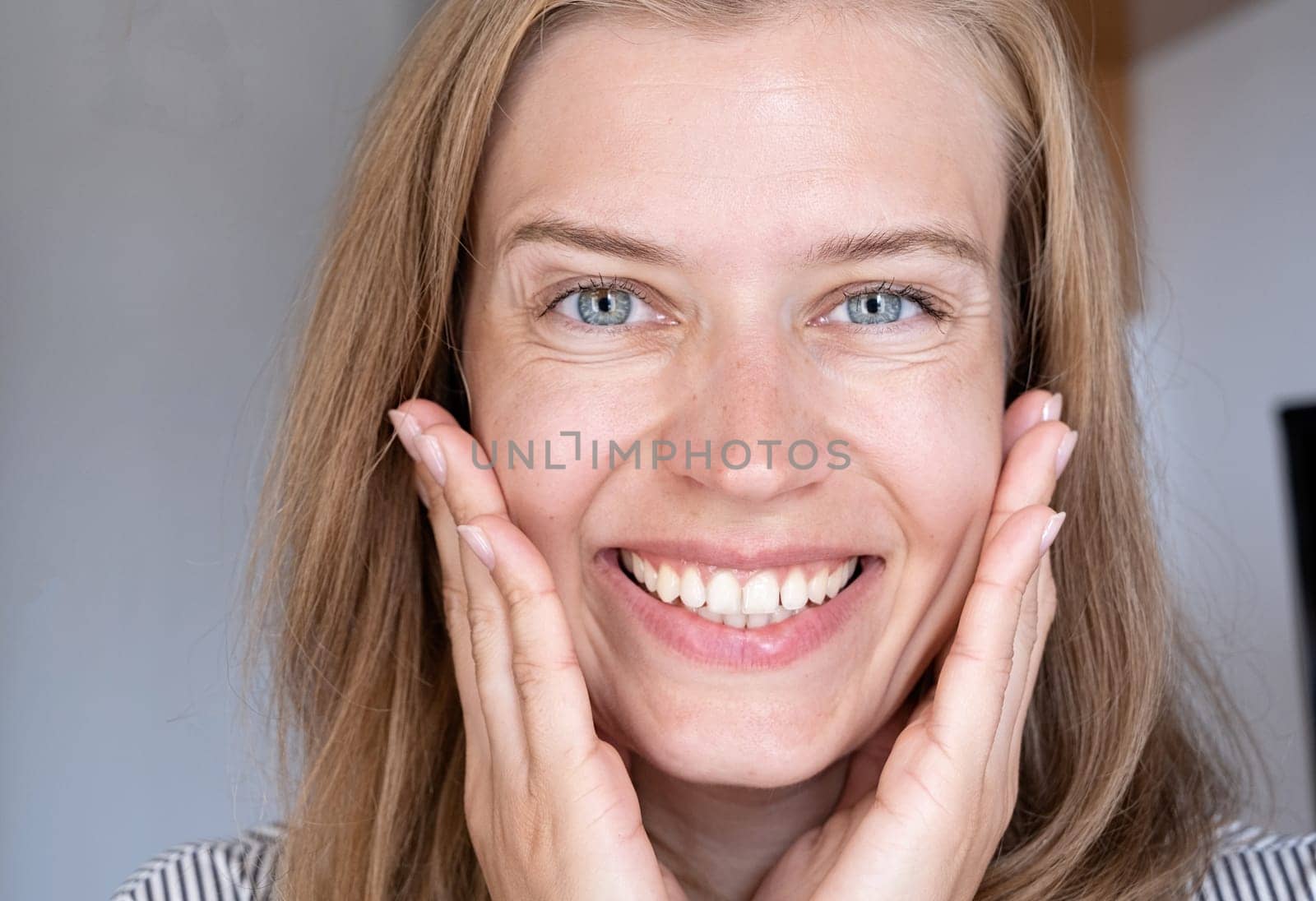 Blonde female looking at camera and smiling. Youth and Skin Care Concept.