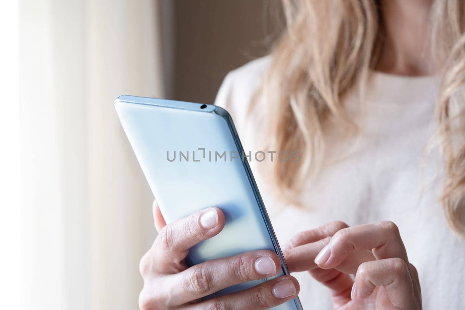 closeup of unrecognizable person in home clothes using phone by Desperada