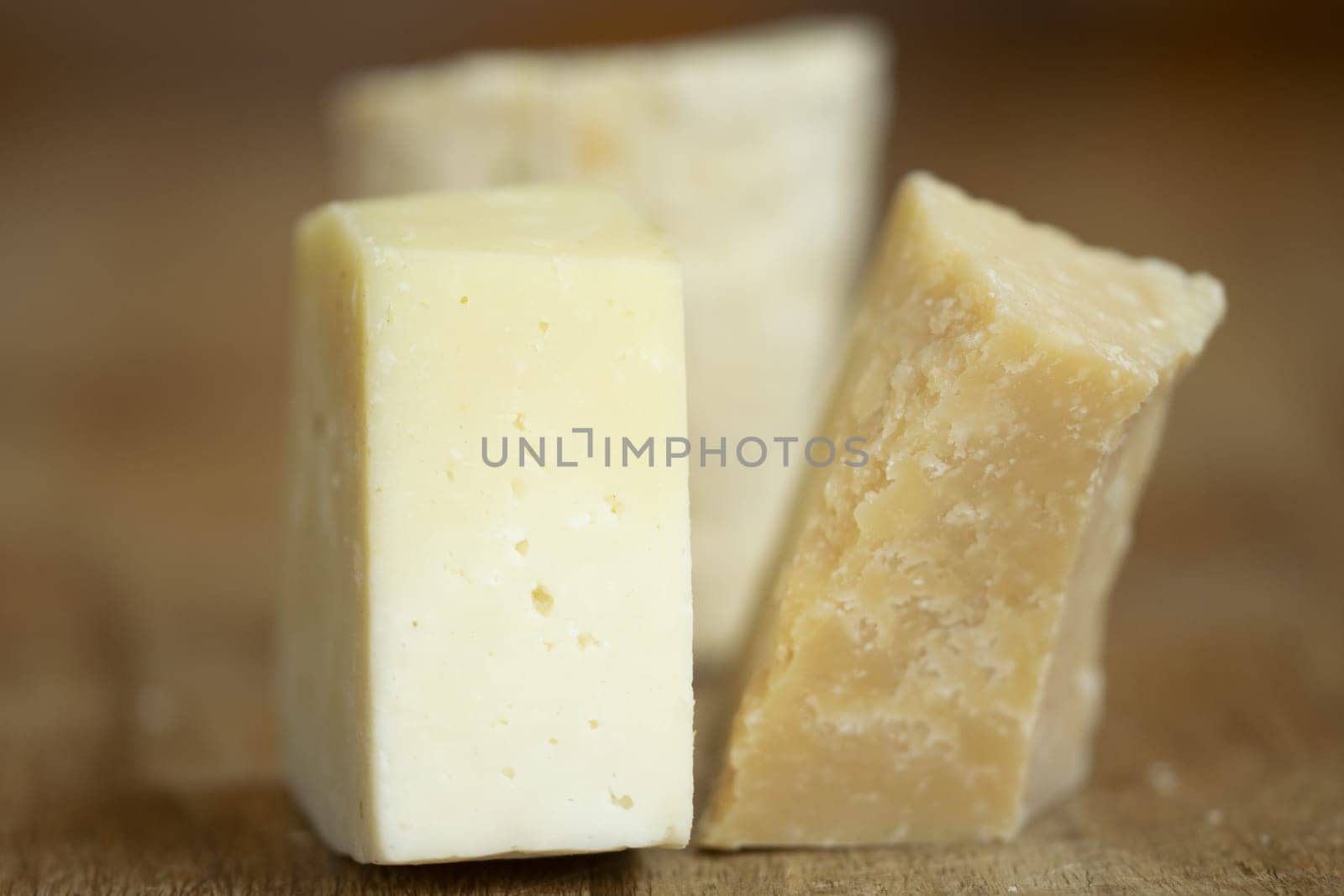 a piece of parmesan cheese next to a piece of pecorino romano