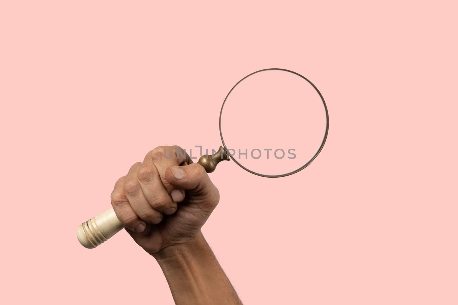 Black male hand holding vintage magnifying loupe on pink background. by TropicalNinjaStudio