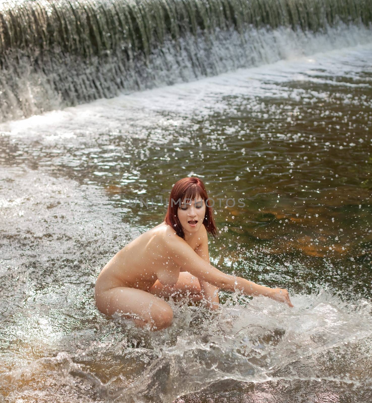 Young nude woman near a forest stream with a waterfall by palinchak