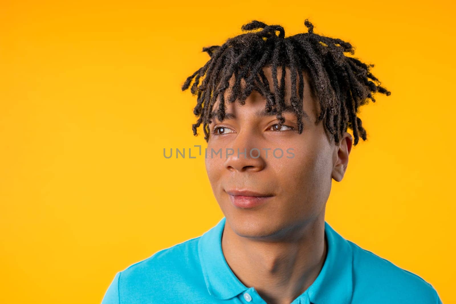 Friendly young man on yellow studio background. Copy space. Teenager student guy by kristina_kokhanova