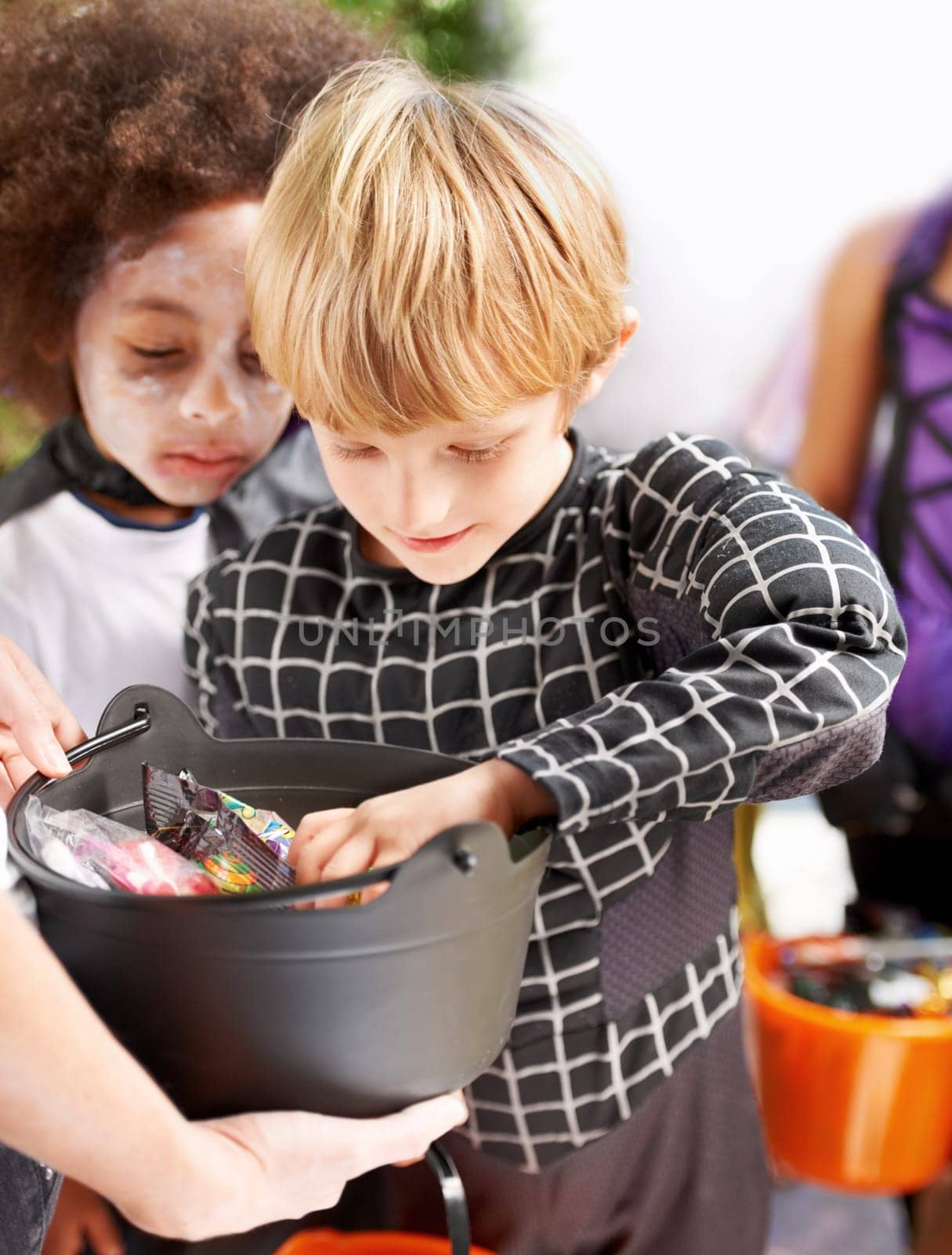 Children, halloween candy and group of friends in neighborhood together for trick or treat tradition. Kids, youth and celebration with young boys collecting sweets for spooky holiday or vacation by YuriArcurs