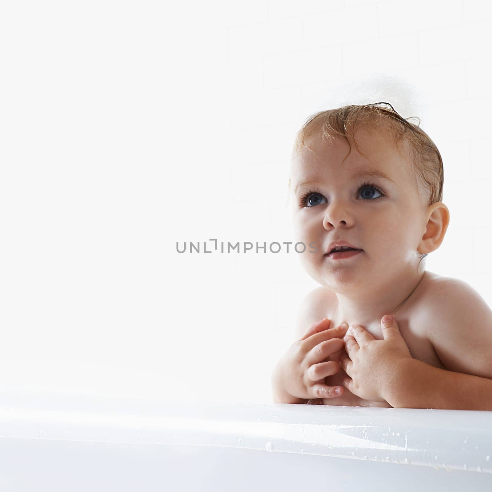 Face of baby in bath, clean skin with mockup in morning routine for health, wellness and body care in home. Cute toddler washing in water with hygiene, relax and calm child sitting in tub in bathroom.