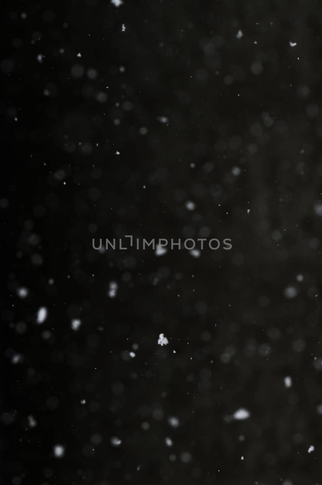 Bokeh of white snow on a black background. Snowfall - design element. by Niko_Cingaryuk