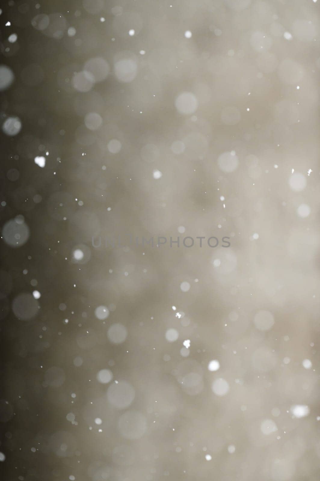 Bokeh of white snow on a light background. Falling snowflakes, isolated for post production and overlay in graphic editor.