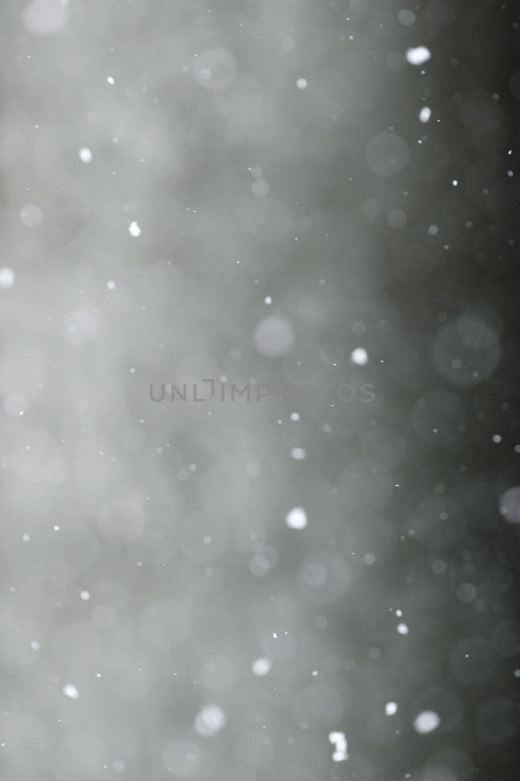 Falling snowflakes on night sky background, isolated for post production and overlay in graphic editor. Bokeh of white snow on a square shape gray background.
