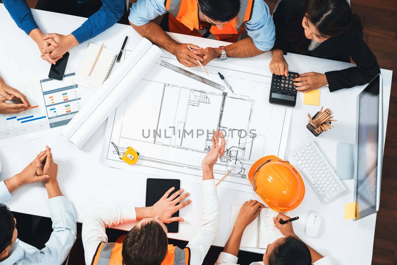 Top view banner of diverse group of civil engineer and client working together on architectural project, reviewing construction plan and building blueprint at meeting table. Prudent